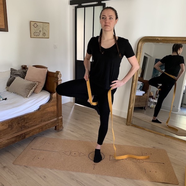 jeune femme réalise posture de yoga avec sangle d'étirements et tapis de yoga made in europe yogom