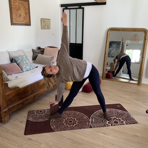 jeune femme en posture du triangle avec brique en mousse d'eva recyclé et tapis de yoga yogom
