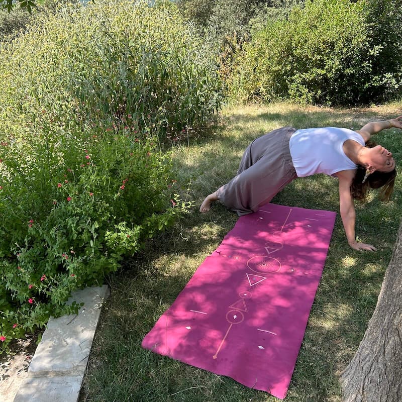 tapis de yoga de voyage Yogom Samadhi framboise - pratique dans l'herbe