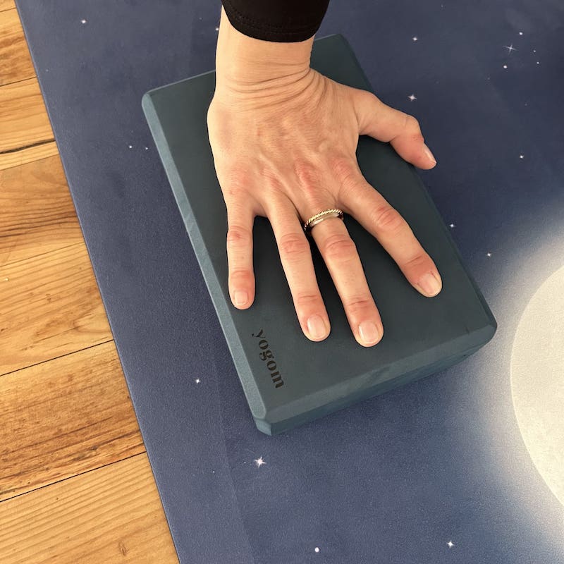 main d'une yogi sur brique de yoga Yogom bleu focus main sur brique