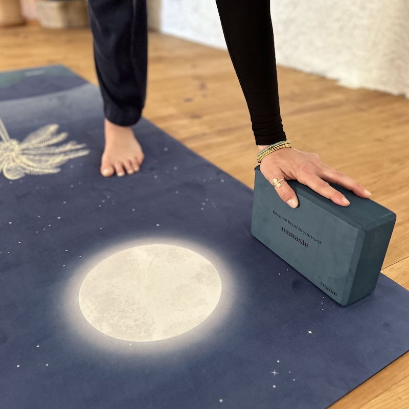 main d'une yogi sur brique de yoga Yogom bleu
