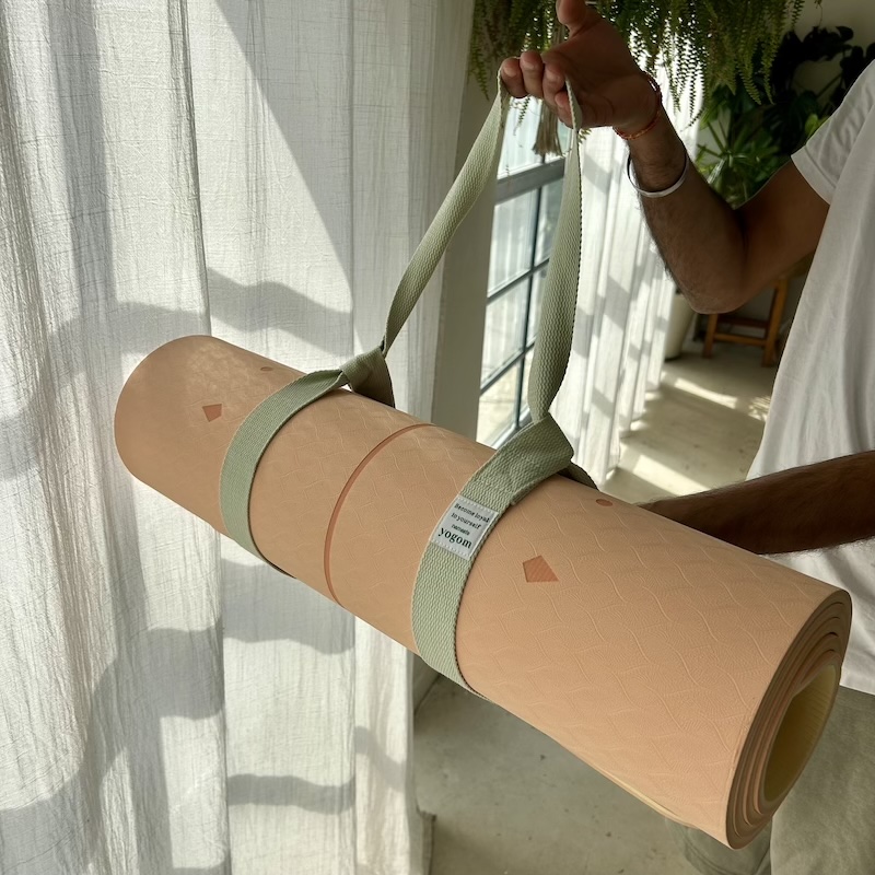 Tapis de yoga Yomad Samadhi corail Yogom porté avec une sangle de transport